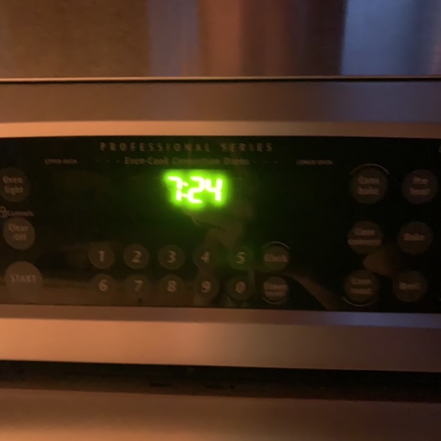 A blurry picture of an oven clock showing 7:24